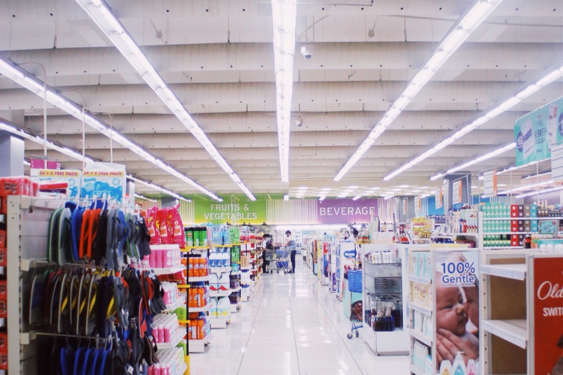 Rayons d’un magasin éclairés par des lignes de luminaires